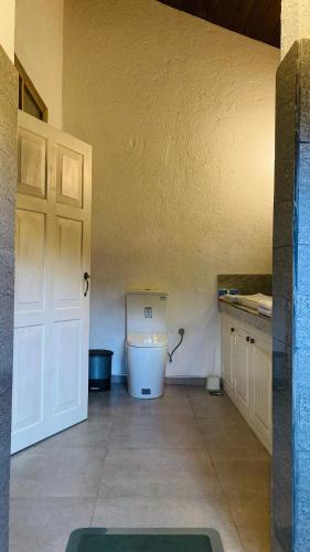 a bathroom with a white toilet in a room at Whispering House in Tangalle