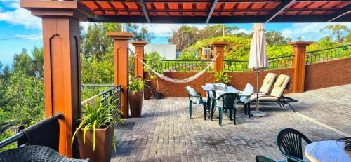 a patio with a table and chairs and a hammock at GuestReady - Quinta das Estrelas in Campanário