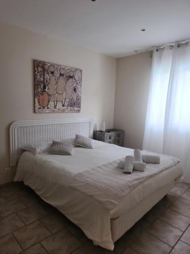 a bedroom with a large white bed with two pillows at Appartement PALAZZI 1 in LʼÎle-Rousse