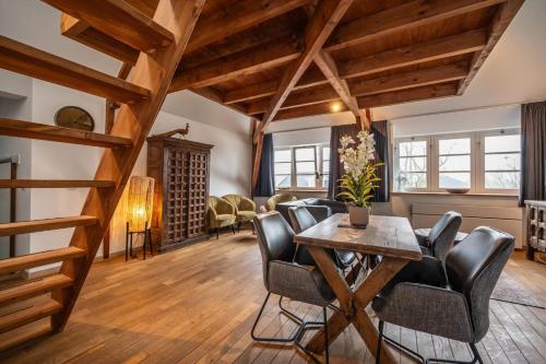 a living room with wooden ceilings and a table and chairs at Spoorzicht Long Stay Apartments in Loppersum