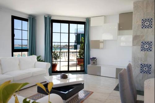 un soggiorno con un divano bianco e un tavolo di THE BAXMAN SUITE - A suite on the shore a Corralejo
