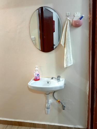 a bathroom with a sink and a mirror at Cozy 1BR Apartment along Eldoret-Kisumu road close to Eldoret Polytechnic and Elgon View Hospital in Eldoret