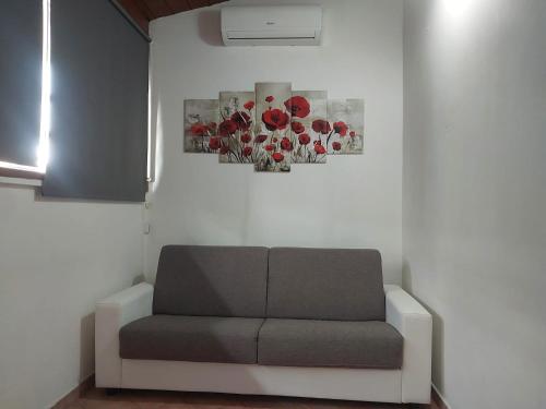 a couch in a room with two paintings on the wall at Villino indipendente con cortile privato 4 p letto - Sul Mare vicino Aeroporto e Fiera in Fiumicino