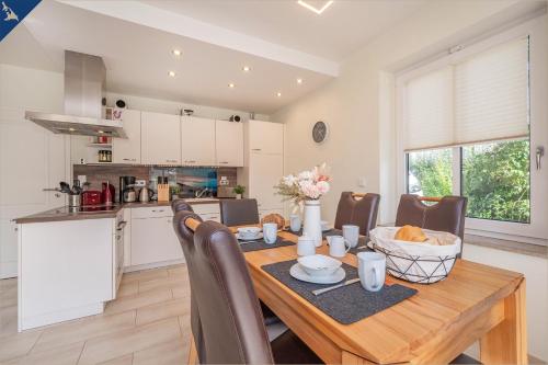 a kitchen and dining room with a wooden table and chairs at Heimathafen An Seen & Meer in Korswandt