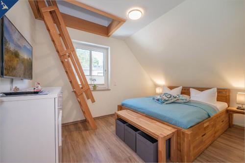 ein Schlafzimmer mit einem Bett und einer Leiter in der Unterkunft Heimathafen An Seen & Meer in Korswandt