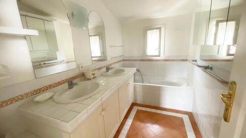 une salle de bain blanche avec deux lavabos et un miroir dans l'établissement Villa Les Cistes, à La Colle-sur-Loup