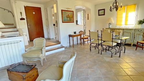 un salon avec des chaises et une table et une cuisine dans l'établissement Villa Les Cistes, à La Colle-sur-Loup