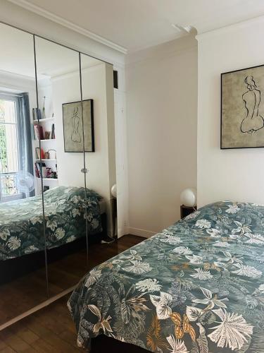 une chambre avec un lit et un miroir dans l'établissement Charmant 2 pièces aux portes de Paris, à Levallois-Perret