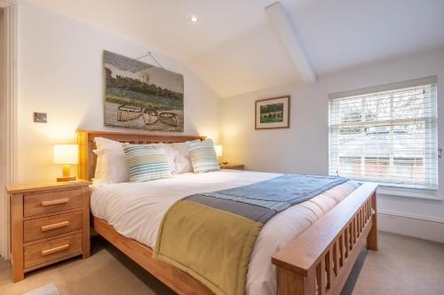 een slaapkamer met een groot bed en een raam bij Bluebell Cottage LW in Little Walsingham