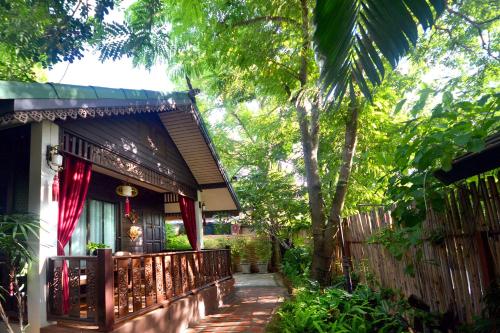 a house with a fence in front of it at Thai Thai Sukhothai Resort in Sukhothai