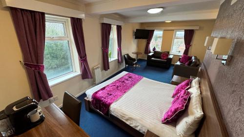 a bedroom with a bed and a living room at The Continental Hotel, Derby in Derby