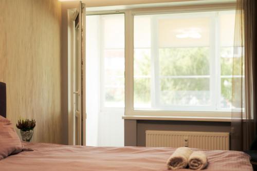 a bedroom with a window and two towels on a bed at Centrinė aikštė in Nida