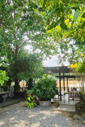 a garden with a pavilion and benches and trees at Banjearanaihomestay Ayutthaya in Phra Nakhon Si Ayutthaya