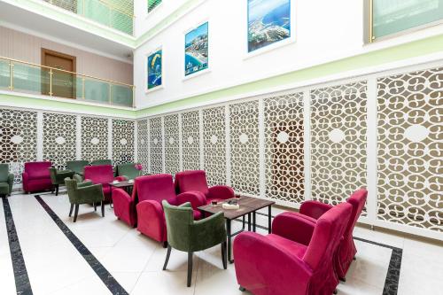 a restaurant with pink chairs and tables in a room at The Suites in Antalya