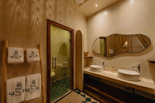 a bathroom with two sinks and a mirror at Riad Senja in Marrakech