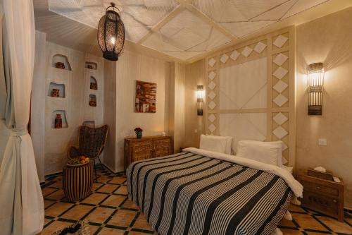 a bedroom with a bed with a black and white blanket at Riad Senja in Marrakech