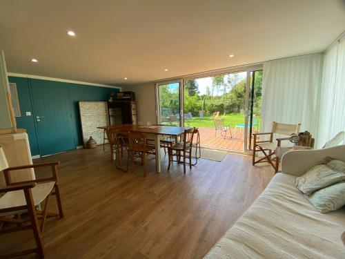 un salon avec un canapé, une table et des chaises dans l'établissement Maison de famille- vue sur mer - 6 à 8 personnes, à Quinéville