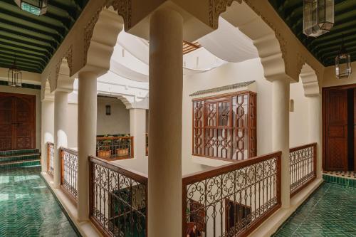 a corridor of a building with pillars and wooden doors at Riad Senja in Marrakech