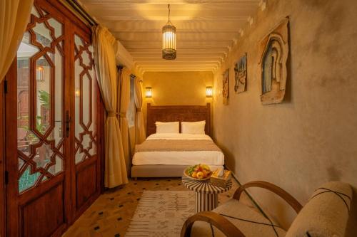 a bedroom with a bed and a table with fruit on it at Riad Senja in Marrakech