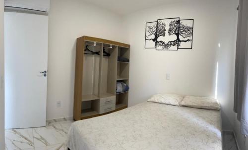 - une chambre blanche avec un lit et une armoire dans l'établissement S3 - Lindo Apartamento em região central, à Foz do Iguaçu