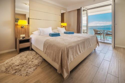 sypialnia z łóżkiem i widokiem na ocean w obiekcie Hotel Vila Rova w mieście Malinska