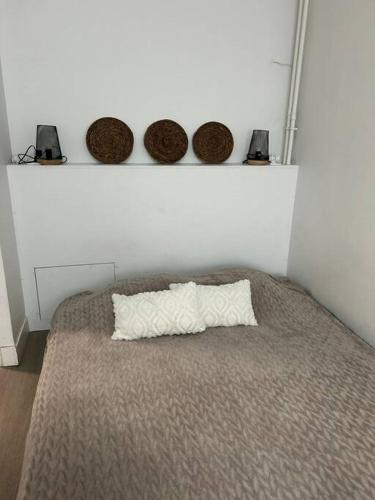 un lit avec trois paniers sur un mur blanc dans l'établissement Authentique Paris Aubervilliers, à Aubervilliers