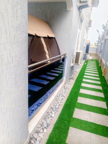 a stairway with green grass on the side of a building at Sugarville, Swimming pool with a Rooftop in Accra