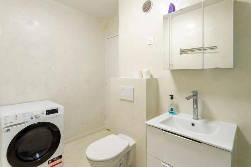 La petite salle de bains est pourvue d'un lavabo et d'un lave-linge. dans l'établissement Authentique Paris Aubervilliers, à Aubervilliers