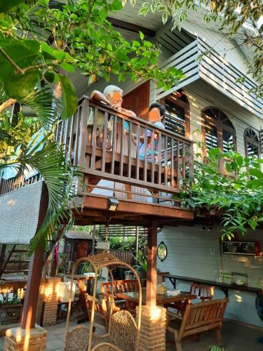 two people sitting on the balcony of a house at Banjearanaihomestay Ayutthaya in Phra Nakhon Si Ayutthaya