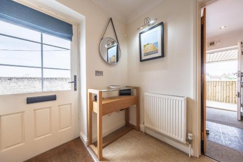 a hallway with a door and a table and a window at Out of Focus in Titchwell
