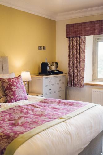 a bedroom with a large bed and a kitchen at The Manor Boutique Hotel Restaurant and Bar in Conwy
