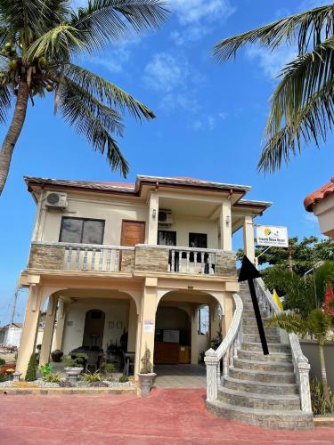 a house with stairs and a palm tree at Seaside Beach Resort in San Fabian