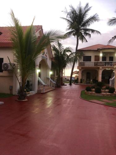 a house with palm trees in front of a driveway at Seaside Beach Resort in San Fabian