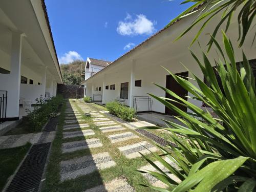 an empty courtyard of a building with plants at Selong Holiday in Selong Belanak