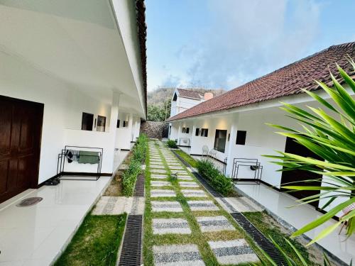an empty courtyard of a building with grass at Selong Holiday in Selong Belanak
