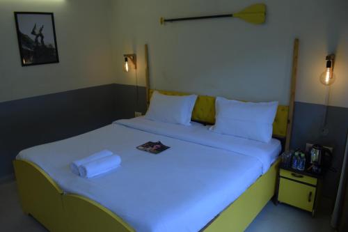 a bedroom with a bed with a book on it at Julley Commune Rishikesh in Rishīkesh