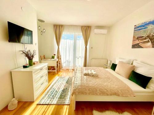 sypialnia z łóżkiem z komodą i oknem w obiekcie Libás Apartman w mieście Keszthely