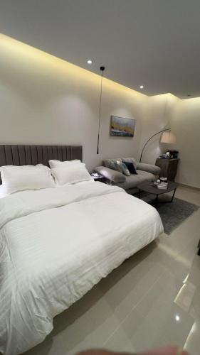 una camera con un grande letto bianco e un soggiorno di استديو بموقع مميز بدخـول ذاتي a Riyad
