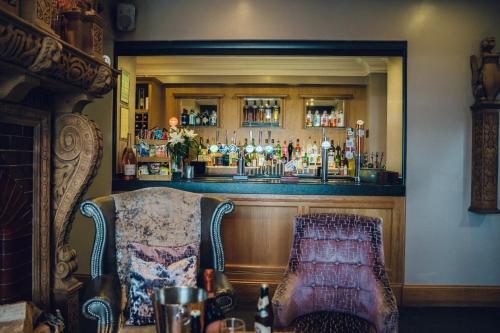 a bar with a chair in front of a bar at The Manor Boutique Hotel Restaurant and Bar in Conwy