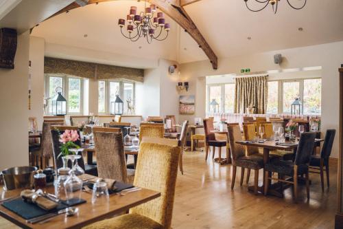 a dining room with tables and chairs and windows at The Manor Boutique Hotel Restaurant and Bar in Conwy