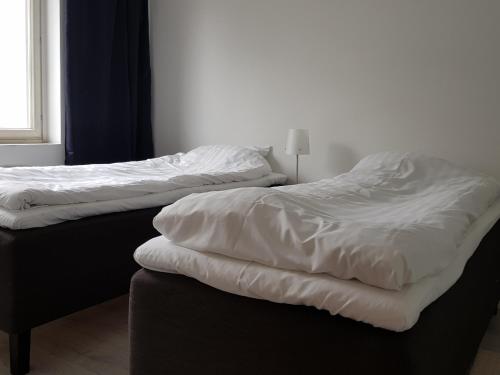 due letti uno accanto all'altro in una stanza di Kotimaailma Apartments - 1BR in city center of Turku a Turku