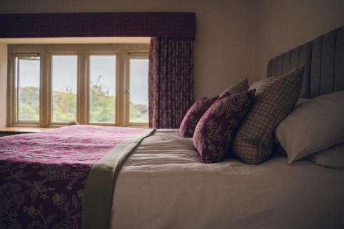 a bedroom with a bed with pillows and a window at The Manor Boutique Hotel Restaurant and Bar in Conwy