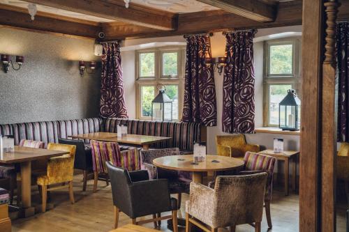 a restaurant with tables and chairs and windows at The Manor Boutique Hotel Restaurant and Bar in Conwy