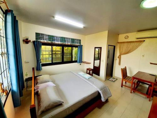 a bedroom with a bed and a desk and a window at Banjearanaihomestay Ayutthaya in Phra Nakhon Si Ayutthaya