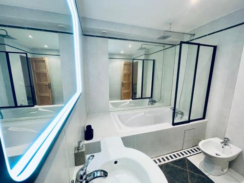 a bathroom with a sink and a tub and a toilet at Appartement au calme avec terrasse verdoyante entre Annecy et Genève in Villy-le-Pelloux