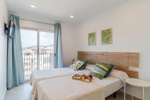 a bedroom with two beds and a large window at 4238 - AB Duplex Santa Coloma III in Santa Coloma