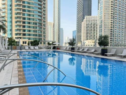 a large swimming pool in a city with tall buildings at Panoramic Full Fountain,Opera& burj Sky View 4BR APT in Dubai