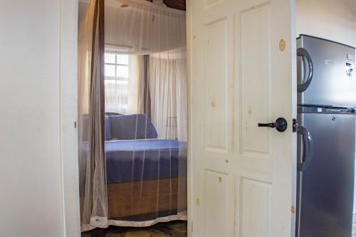 a door leading to a bedroom with a refrigerator at Montete Hilltop Cottage with Stunning Panoramic Views in Jalousie