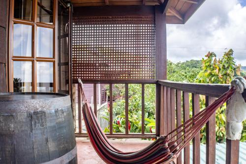 a hammock on the porch of a house at Montete Hilltop Cottage with Stunning Panoramic Views in Jalousie