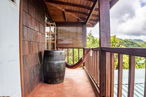 a porch with a large barrel and a hammock at Montete Hilltop Cottage with Stunning Panoramic Views in Jalousie